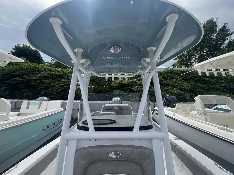 Slide: The Image of 2025 Sea Hunt Ultra 219 boat with T-top and seating, docked. - 6