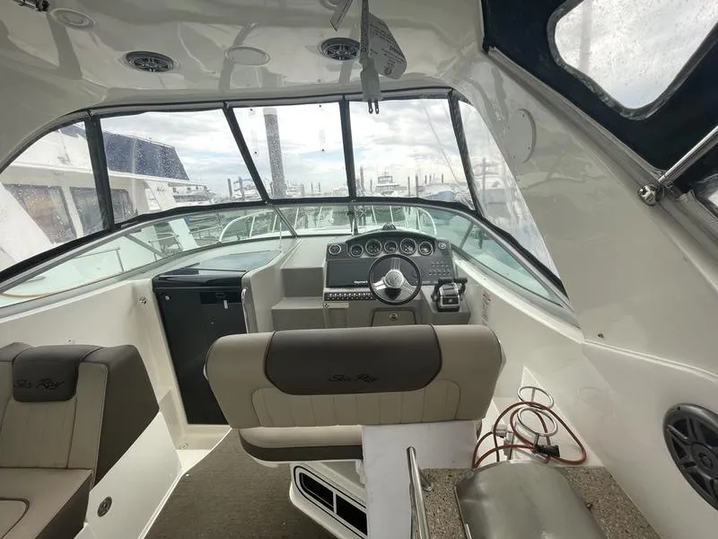 Slide: The Image of 2014 Sea Ray 310 Sundancer boat cockpit with steering wheel and seating. - 12