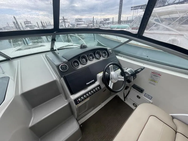 Slide: The Image of 2014 Sea Ray 310 Sundancer helm with modern controls and navigation system. - 3