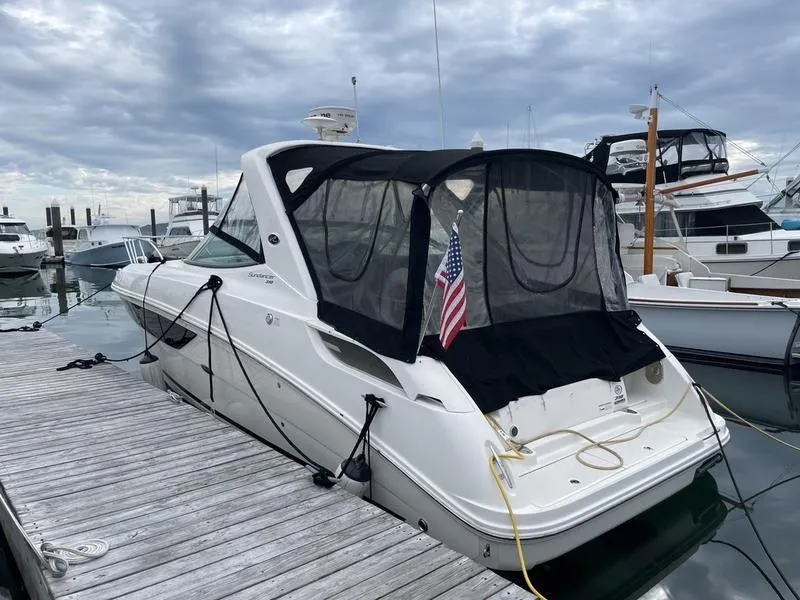 Slide: The Image of 2014 Sea Ray 310 Sundancer docked at marina with American flag. - 4