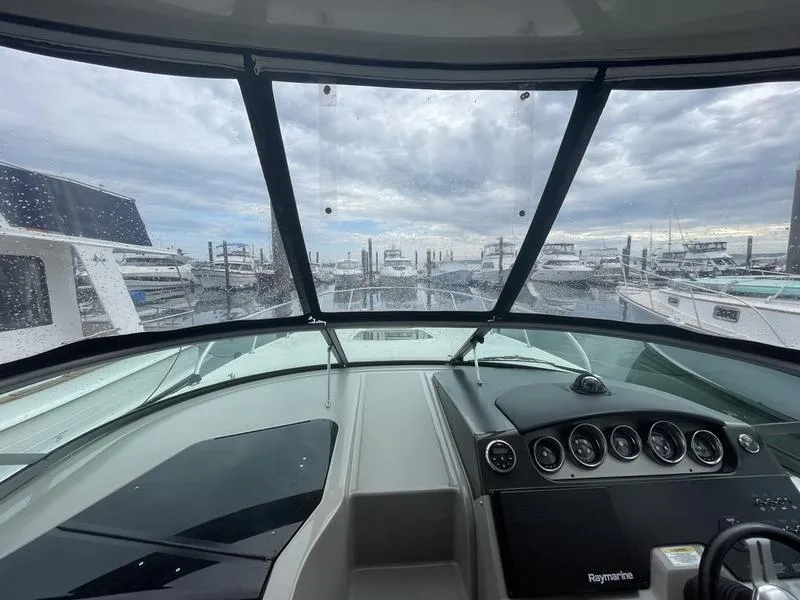 Slide: The Image of View from the helm of a 2014 Sea Ray 310 Sundancer at a marina. - 7