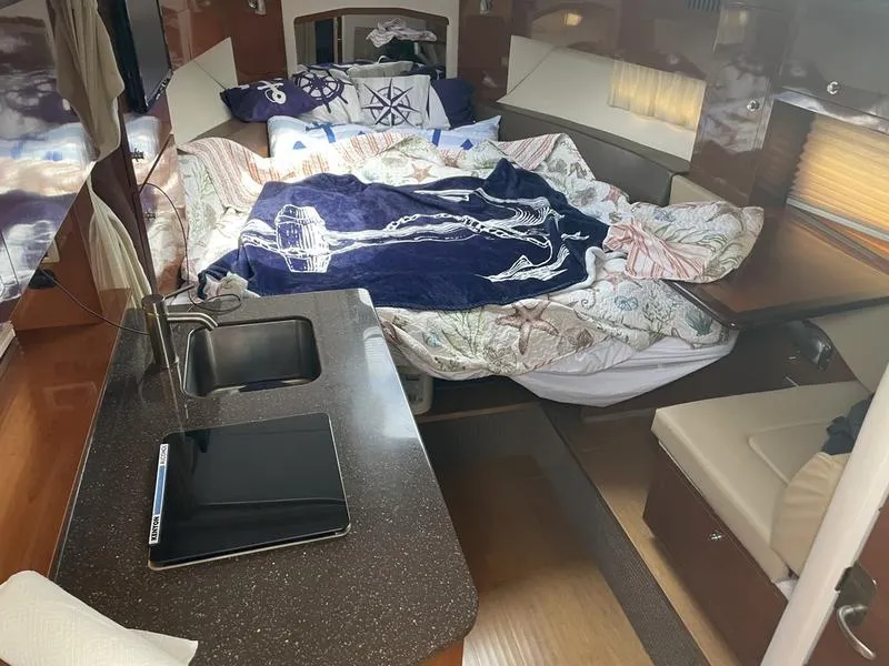 Slide: The Image of Interior of 2014 Sea Ray 310 Sundancer with bed, sink, and seating area. - 9