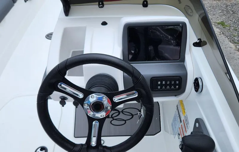 Slide: The Image of 2024 Tahoe T21 boat dashboard with steering wheel and control panel. - 2