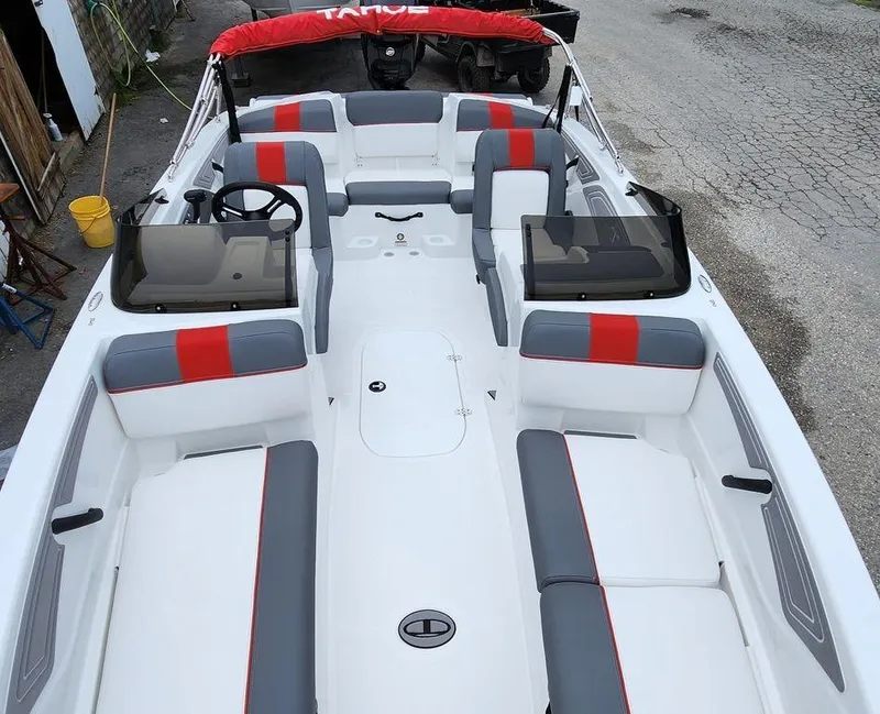 Slide: The Image of 2024 Tahoe T21 boat interior with red and gray seating, dual consoles, and a red canopy. - 4