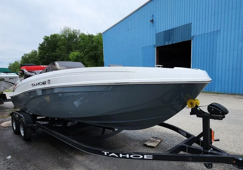 Slide: The Image of 2024 Tahoe T21 boat on trailer near blue building. - 5