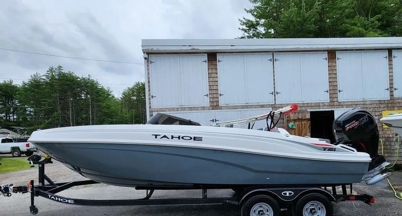 Slide: The Image of 2024 Tahoe T21 boat on a trailer in front of a storage building. - 6