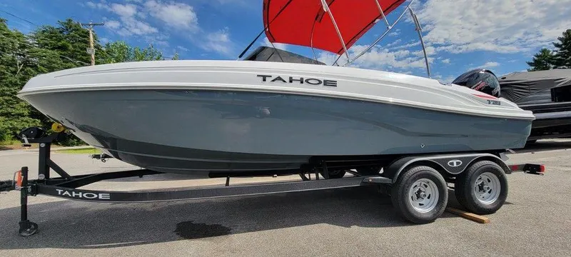 Slide: The Image of 2024 Tahoe T21 boat on trailer with red canopy, parked outdoors. - 8