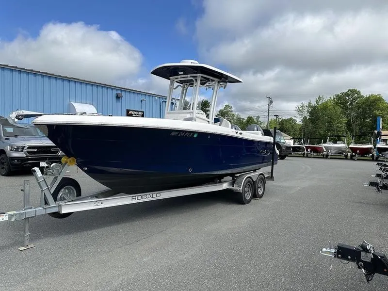 Slide: The Image of 2022 Robalo R242 boat on a trailer in a dealership lot. - 0