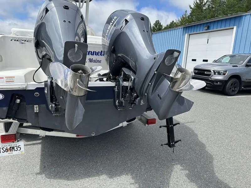 Slide: The Image of 2022 Robalo R242 boat with dual outboard motors in a parking lot. - 1