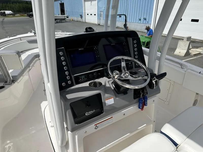 Slide: The Image of 2022 Robalo R242 boat console with dual screens and steering wheel. - 14
