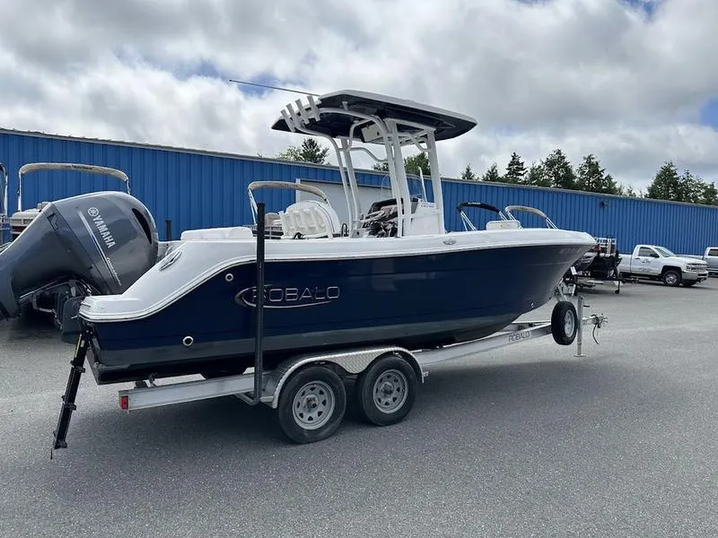 Slide: The Image of 2022 Robalo R242 boat on a trailer in a parking lot. - 2