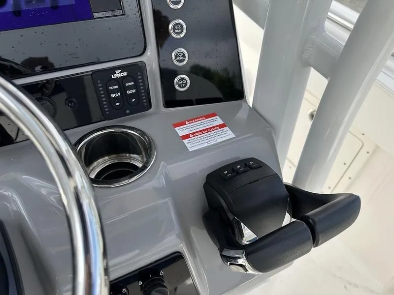 Slide: The Image of 2022 Robalo R242 boat console with steering wheel, controls, and cup holder. - 20