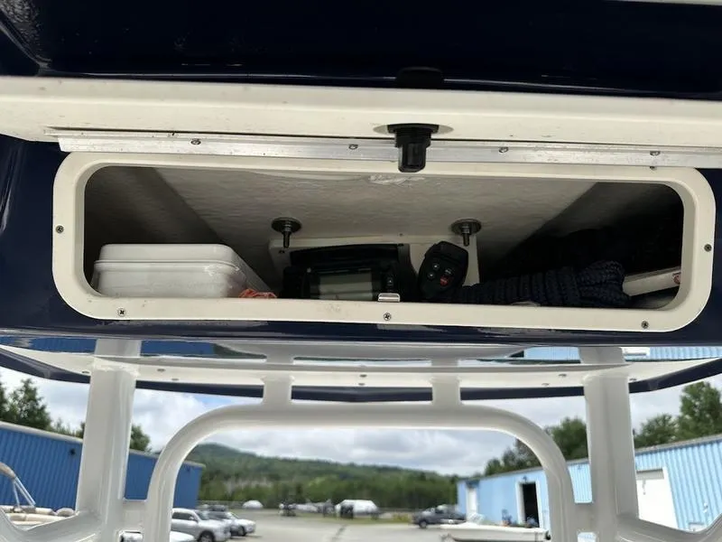 Slide: The Image of Storage compartment on a 2022 Robalo R242 boat with various items inside. - 7