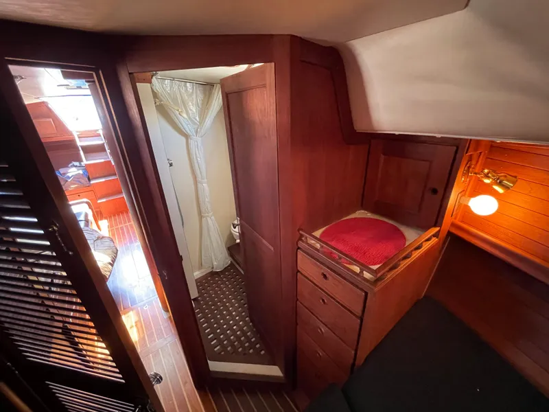 Slide: The Image of 1978 CAL 2-39 yacht interior with wooden cabinetry, cozy lighting, and compact bathroom. - 15