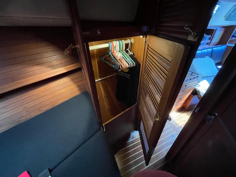 Slide: The Image of 1978 CAL 2-39 sailboat interior with open wooden closet and hangers. - 18