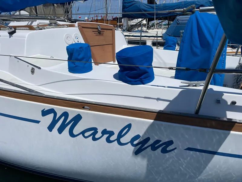 Slide: The Image of 1978 CAL 2-39 sailboat named "Marlyn" with blue covers docked in a marina. - 33