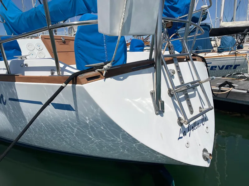 Slide: The Image of 1978 CAL 2-39 sailboat docked, featuring a sleek white hull and blue covers. - 34