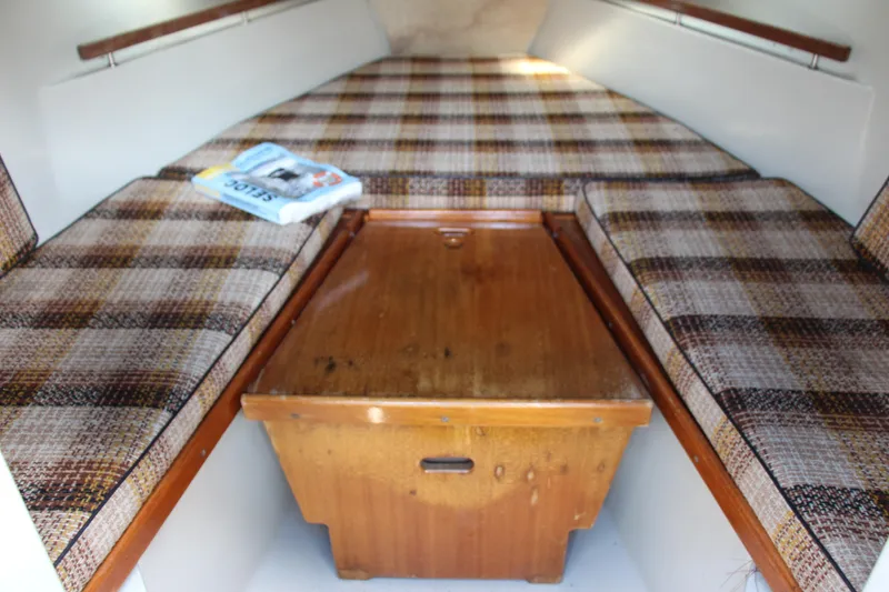 Slide: The Image of Cabin interior of 1985 Boston Whaler Revenge 22 with plaid cushions and wooden table. - 10