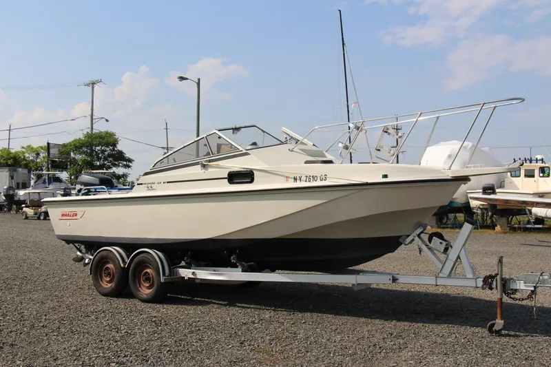 Slide: The Image of 1985 Boston Whaler Revenge 22 boat on a trailer in a marina. - 15