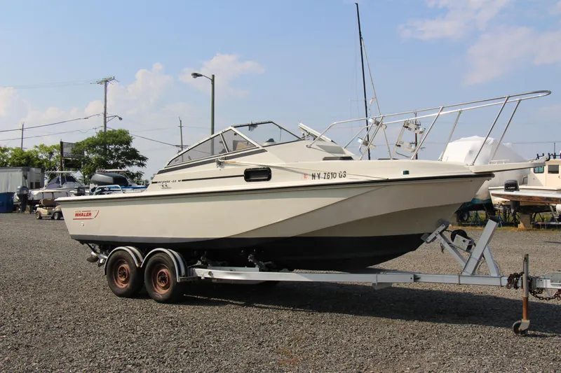 Slide: The Image of 1985 Boston Whaler Revenge 22 boat on a trailer in a marina. - 16
