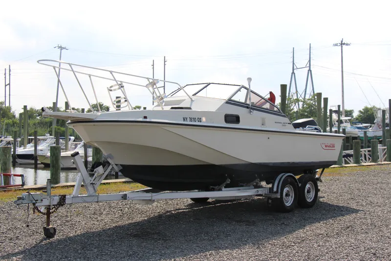 Slide: The Image of 1985 Boston Whaler Revenge 22 boat on a trailer at a marina. - 17
