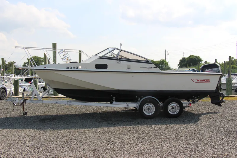 Slide: The Image of 1985 Boston Whaler Revenge 22 boat on a trailer in a marina. - 18