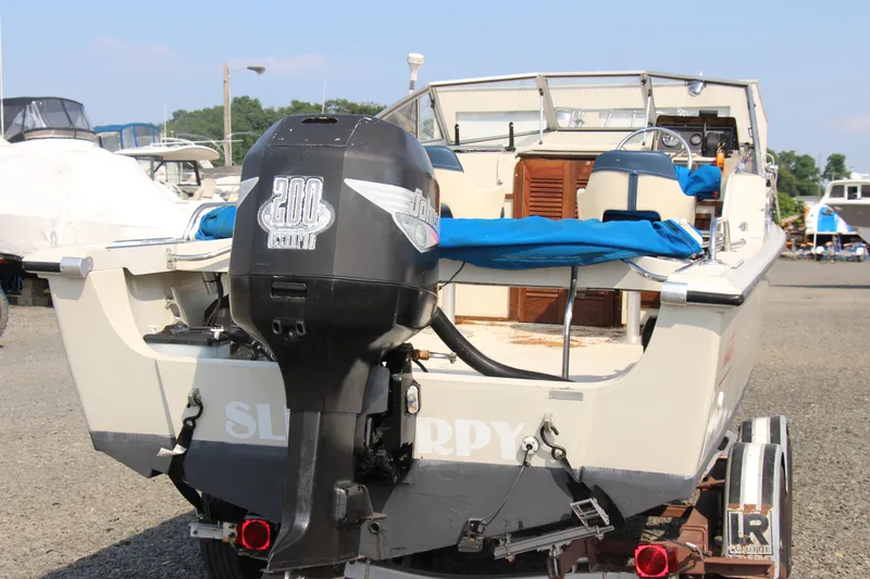 Slide: The Image of 1985 Boston Whaler Revenge 22 boat with outboard motor on trailer. - 19