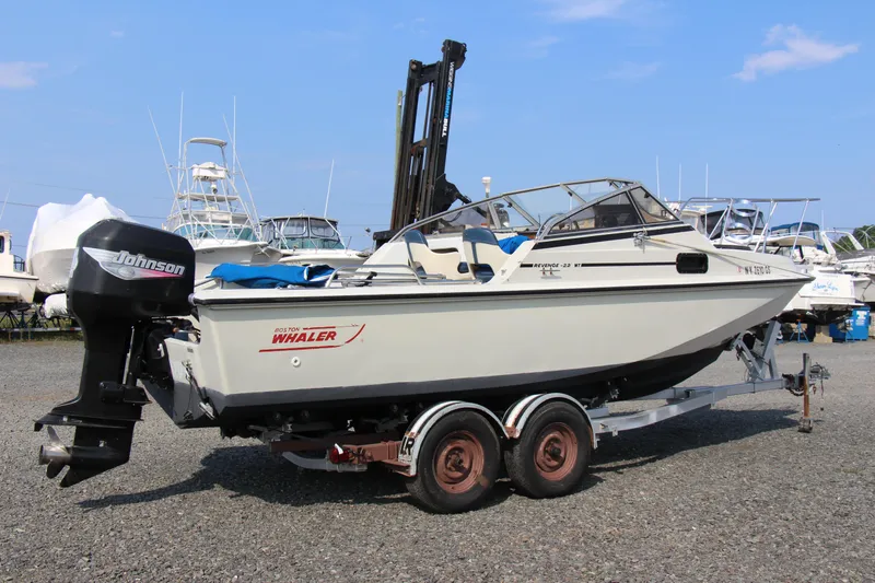 Slide: The Image of 1985 Boston Whaler Revenge 22 boat on a trailer with Johnson outboard motor. - 20
