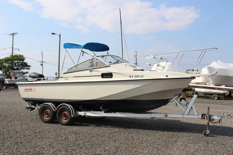 Slide: The Image of 1985 Boston Whaler Revenge 22 boat on a trailer in a marina. - 4