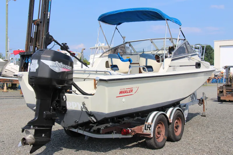 Slide: The Image of 1985 Boston Whaler Revenge 22 boat on trailer with Johnson outboard motor. - 6
