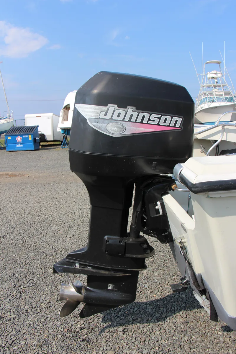 Slide: The Image of 1985 Boston Whaler Revenge 22 with Johnson outboard motor in a boatyard. - 8
