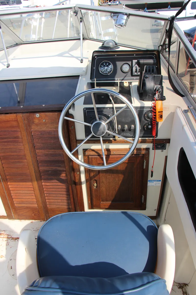 Slide: The Image of 1985 Boston Whaler Revenge 22 boat helm with steering wheel and control panel. - 9