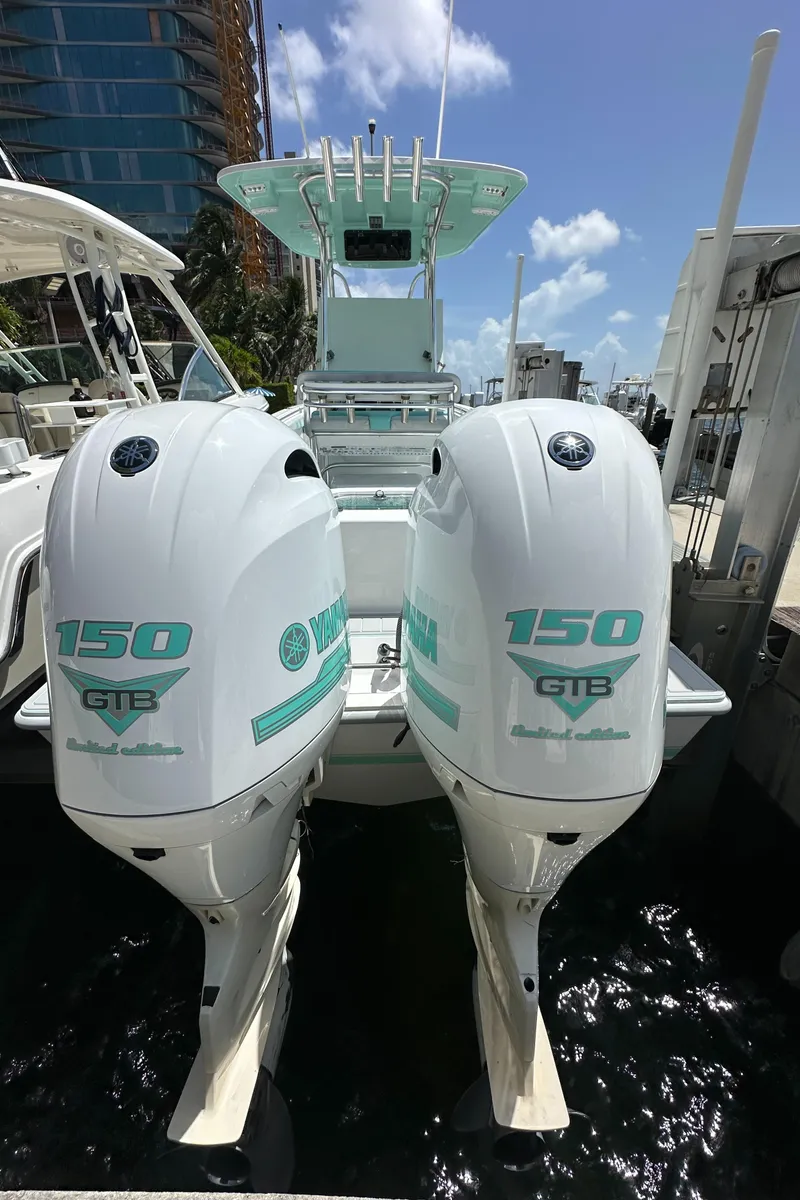 Slide: The Image of 2018 Contender 24 Sport boat with twin 150 HP Yamaha engines docked. - 12