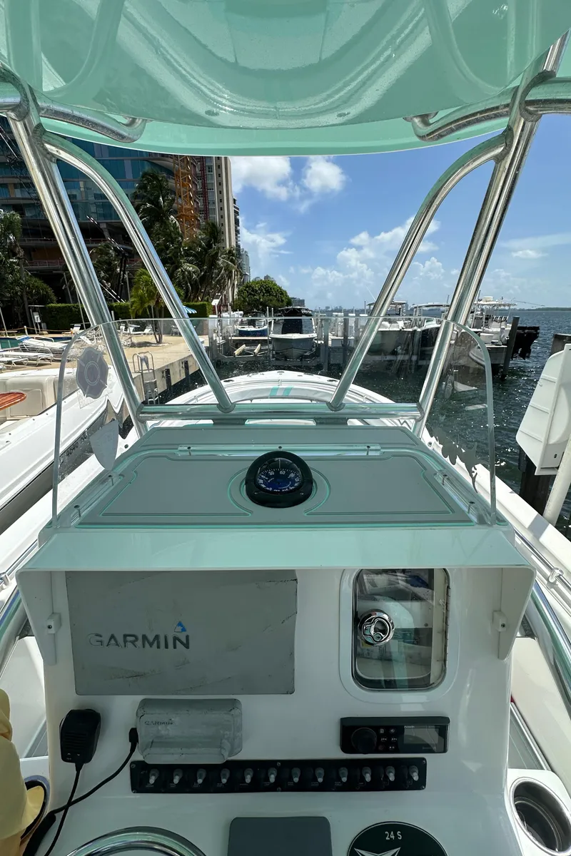 Slide: The Image of 2018 Contender 24 Sport boat dashboard with Garmin navigation system at a marina. - 14