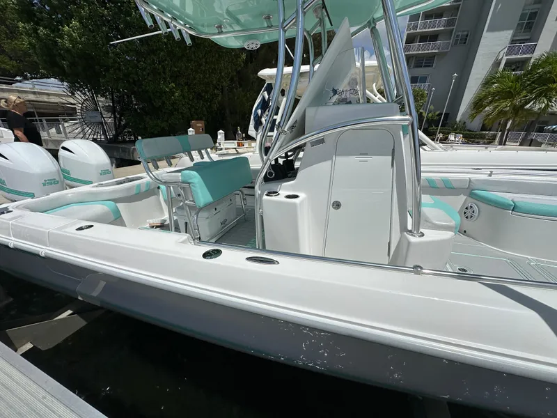 Slide: The Image of 2018 Contender 24 Sport boat docked, featuring teal and white seating. - 3