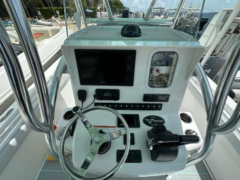 Slide: The Image of 2018 Contender 24 Sport boat console with steering wheel, controls, and navigation system. - 8
