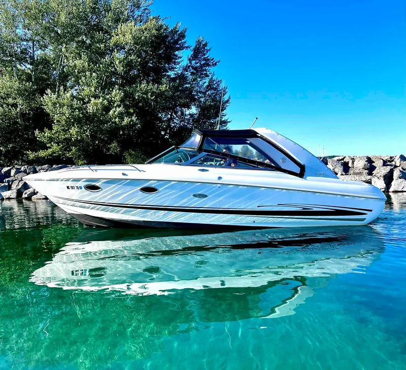 The Image of 2003 Powerquest 280 SC boat on clear water with trees in the background. - 0