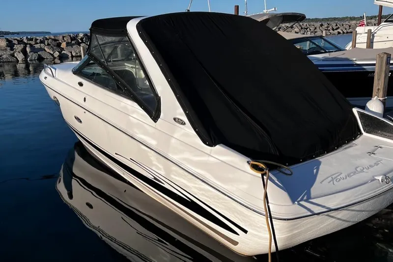 Slide: The Image of 2003 Powerquest 280 SC boat docked in marina with black cover. - 12