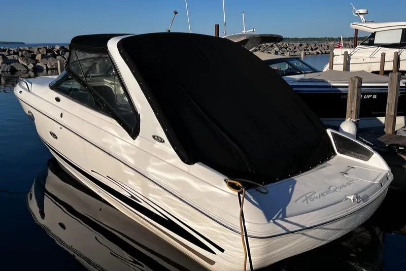 Slide: The Image of 2003 Powerquest 280 SC boat docked in a marina with black cover. - 14