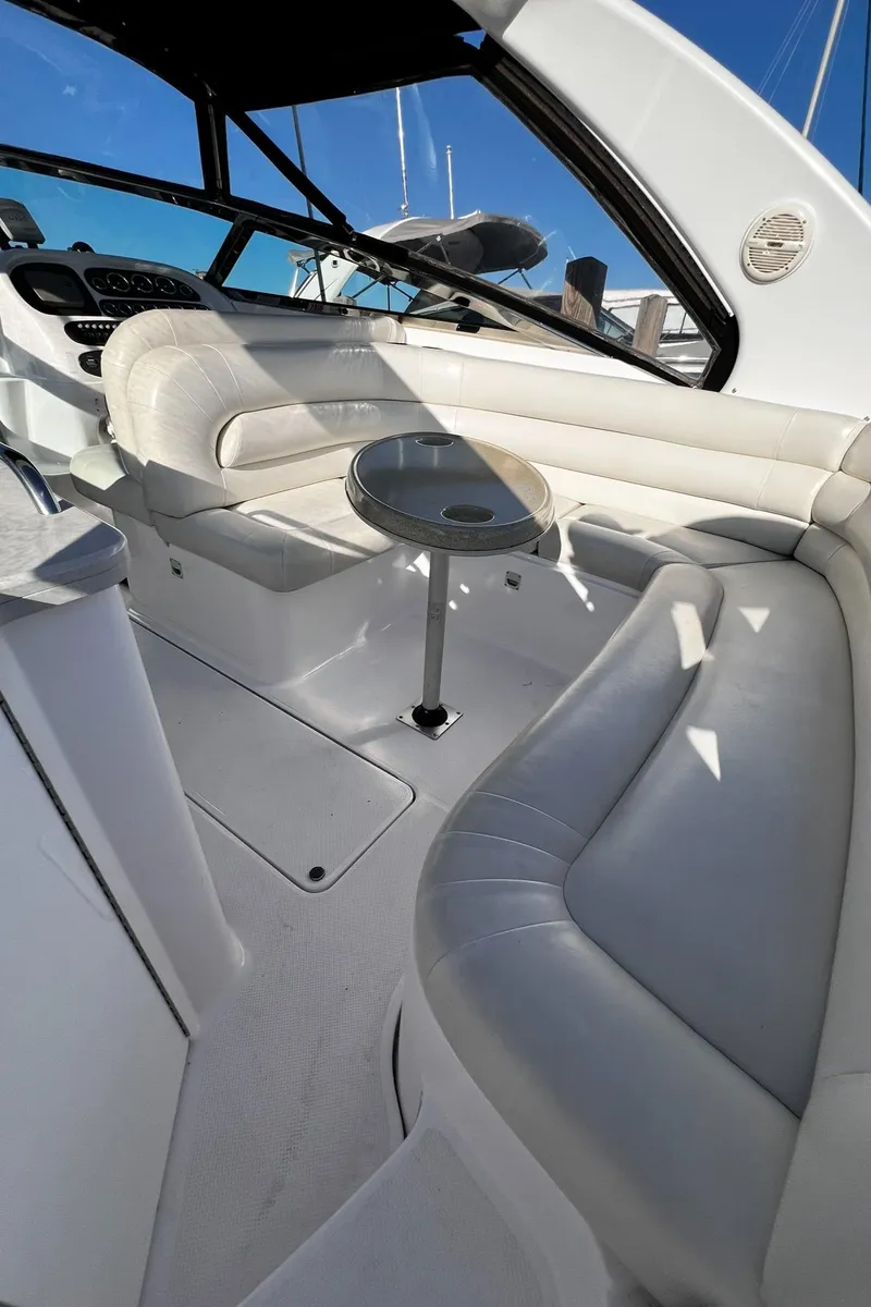 Slide: The Image of 2003 Powerquest 280 SC boat interior with white seating and small table. - 17