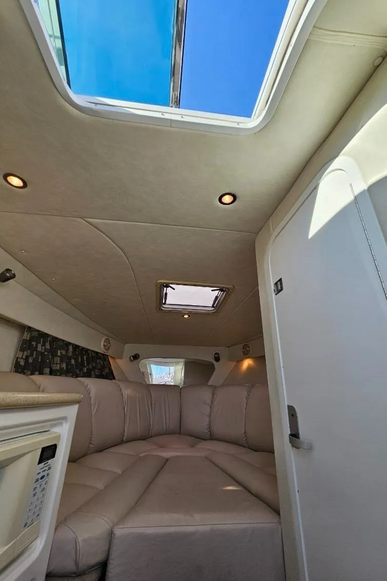 Slide: The Image of Interior cabin of a 2003 Powerquest 280 SC boat with skylight and beige seating. - 24