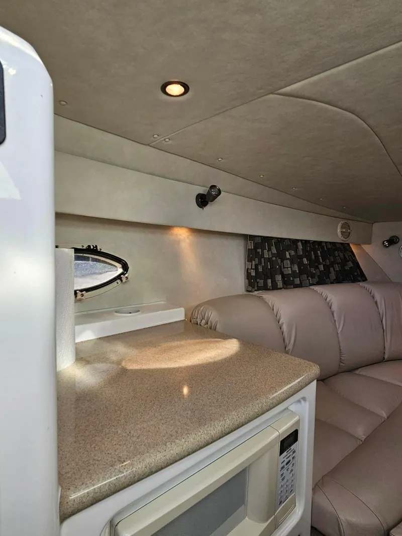Slide: The Image of 2003 Powerquest 280 SC cabin interior with beige seating and countertop. - 26