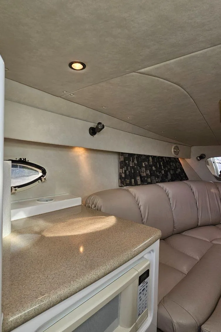 Slide: The Image of Interior of 2003 Powerquest 280 SC boat with beige seating and countertop. - 27