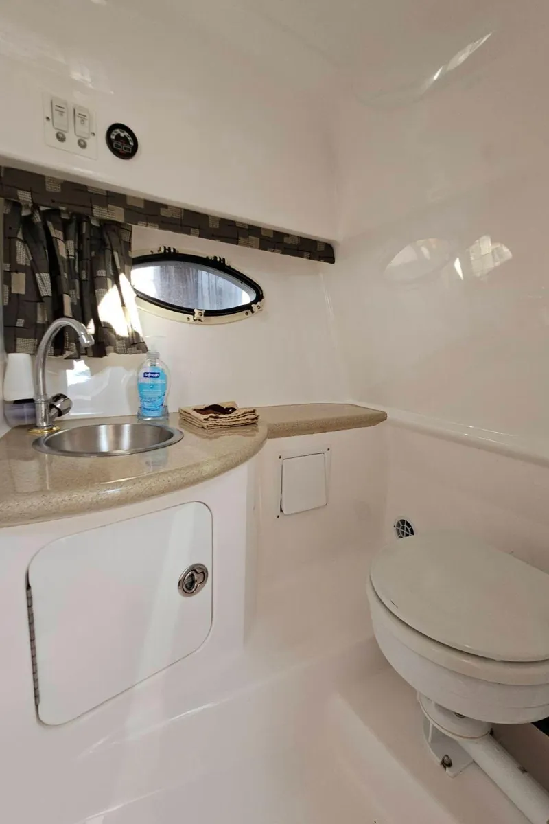 Slide: The Image of 2003 Powerquest 280 SC boat bathroom with sink, toilet, and storage. - 29