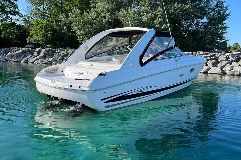 Slide: The Image of 2003 Powerquest 280 SC boat on clear water near rocky shoreline. - 5