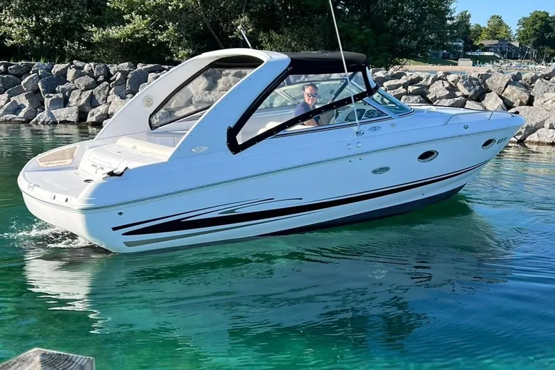 Slide: The Image of 2003 Powerquest 280 SC boat cruising in clear water near rocky shore. - 6