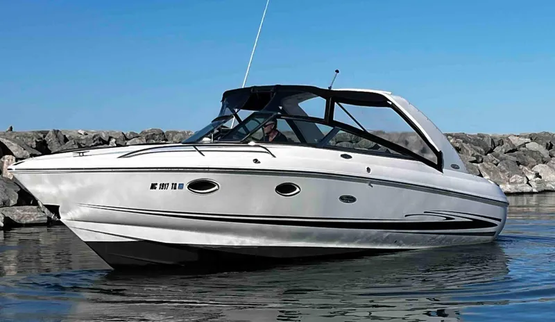 Slide: The Image of 2003 Powerquest 280 SC boat on calm water near rocky shore. - 7