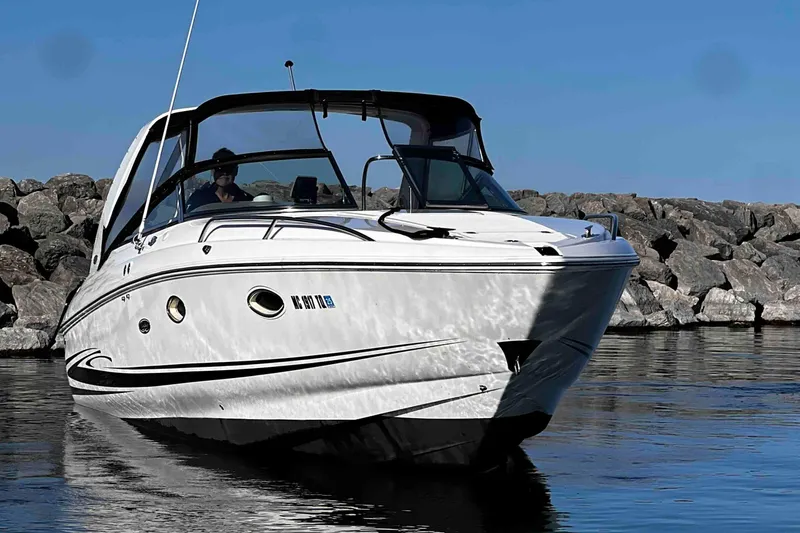 Slide: The Image of 2003 Powerquest 280 SC boat on calm water near rocky shore. - 8