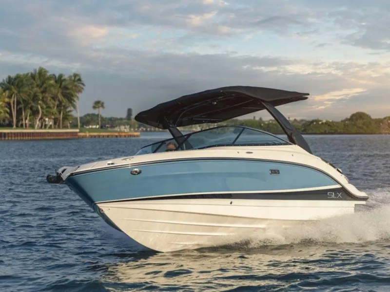 Slide: The Image of 2023 Sea Ray SLX 260 boat cruising on a scenic waterway. - 2