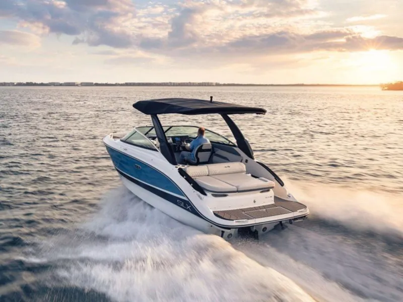 Slide: The Image of 2023 Sea Ray SLX 260 boat cruising on open water at sunset. - 4